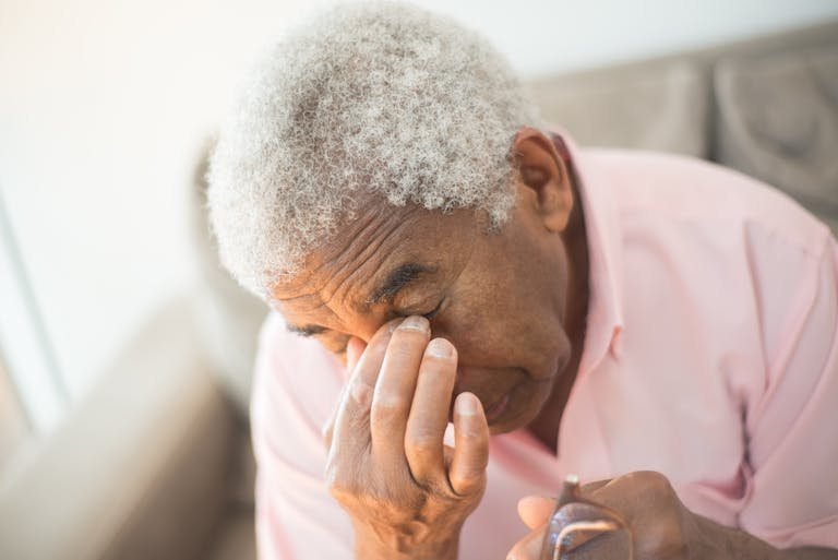 An elderly man with gray hair appears thoughtful in an indoor setting, adding to the contemplative mood.