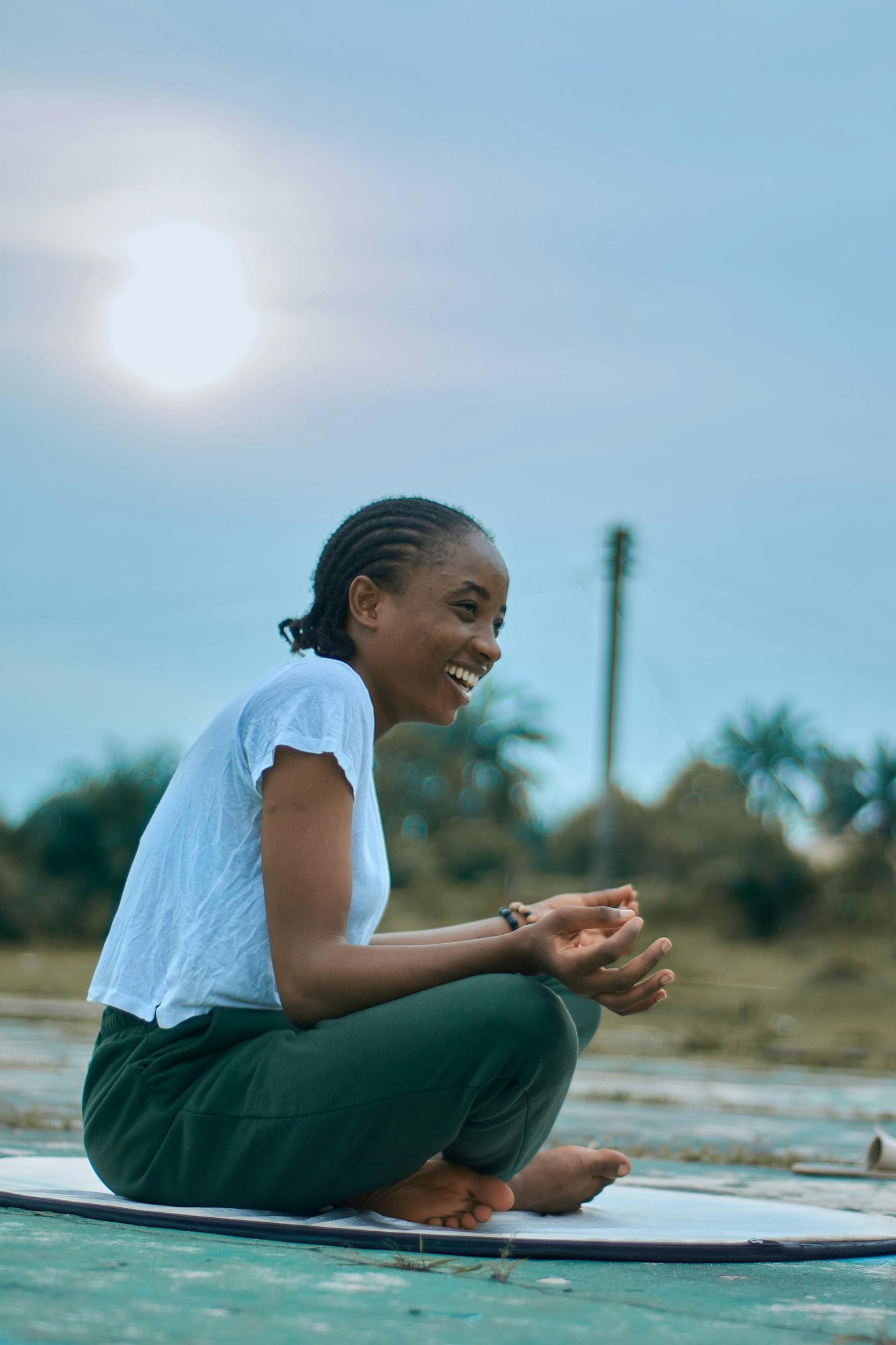 Serene outdoor meditation with a barefoot woman enjoying the sunset
