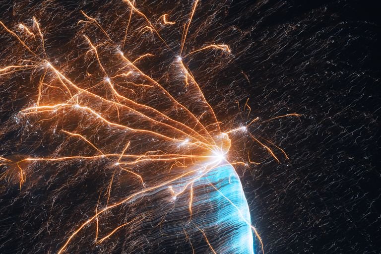 Dazzling fireworks burst in the night sky with vibrant colors and energetic trails.