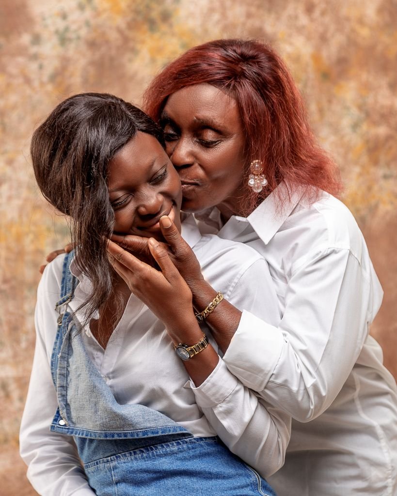 A loving moment between mother and daughter wearing white, captured indoors.